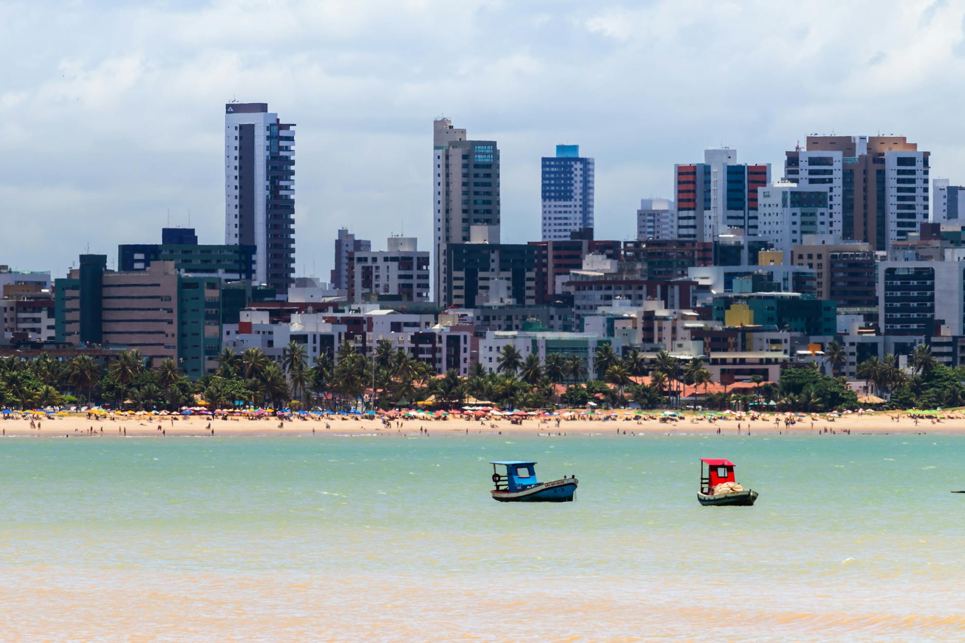 photo of boats on water against city skyline